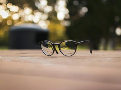 Close up of a pair of stylish glasses on a wooden table